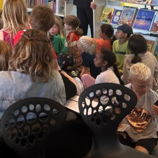 Billede af børn og voksne der får læst højt.