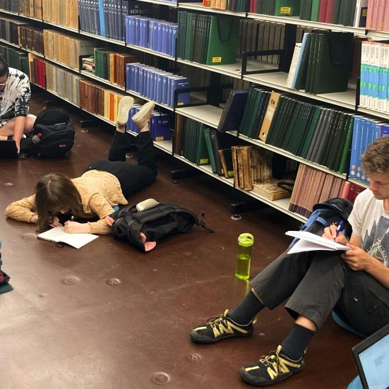 Tre tidligere medlemmer af skriveskolen laver skriveøvelse i Hovedbibliotekets magasin