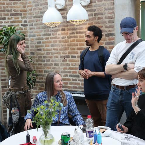 En gruppe mennesker er samlet omkring et bord som står på hovedbiblioteket i Aalborg.